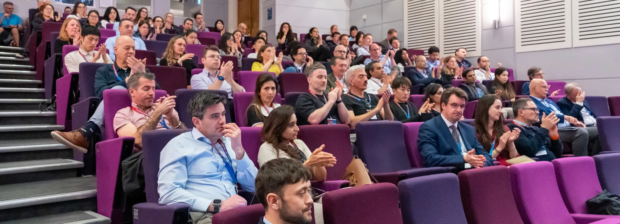 People seated in auditorium for symposium.