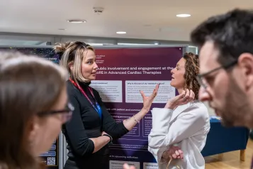 People in discussion in front of academic posters