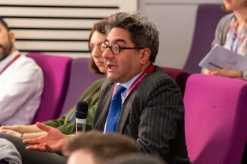 Person in auditorium audience asking question.