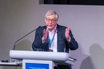 Person presenting on stage at lectern.