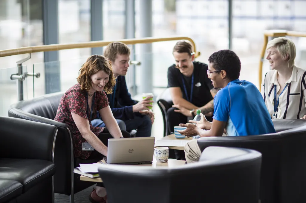 People working at tables in a cafe area.