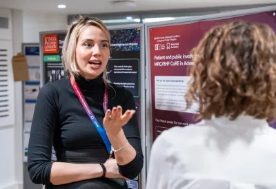 People talking beside academic posters.