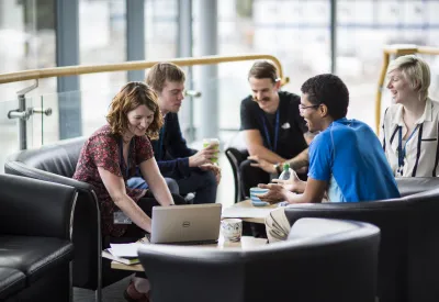 Group of people working at cafe tables.